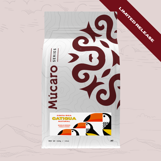 A stand-up pouch of Mucaro Series Costa Rica Catigua Natural coffee beans, featuring a white bag with dark red tribal patterns and a colorful tuxedo graphic, set against a pale pink background with a dark red 'LIMITED RELEASE' banner in the top right corner.