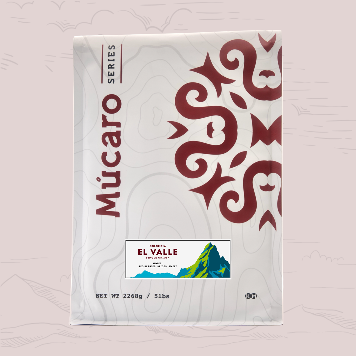 A package of Mucaro Series El Valle coffee from Colombia, shown against a light pink background with subtle topographic line drawings. The package is white with a large dark red Aztec-style graphic on the right, vertical 'Mucaro Series' branding on the left, and the 'El Valle' label near the bottom.